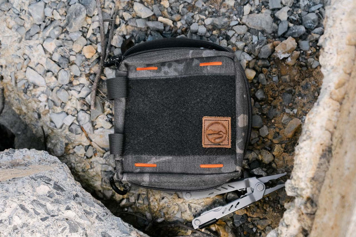 EDC Pouch (multicam black colorway) lifestyle image with gravel and multi-tool