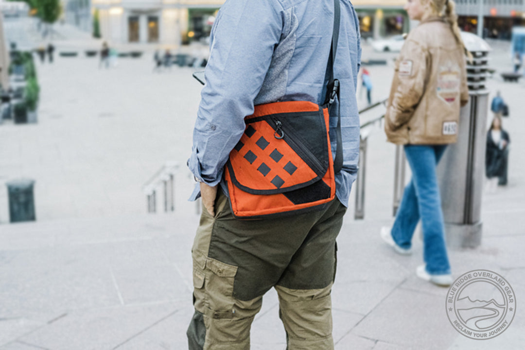 Transit Bag satchel (small messenger bag) by Blue Ridge Overland Gear being carried by a globetrekking man in an urban scene